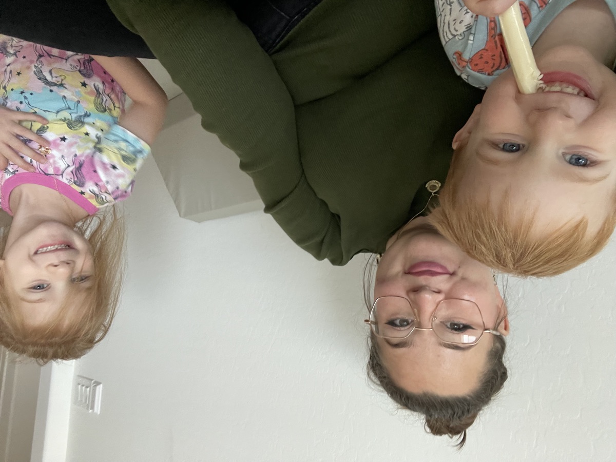 Soraya smiling with two kids on the couch